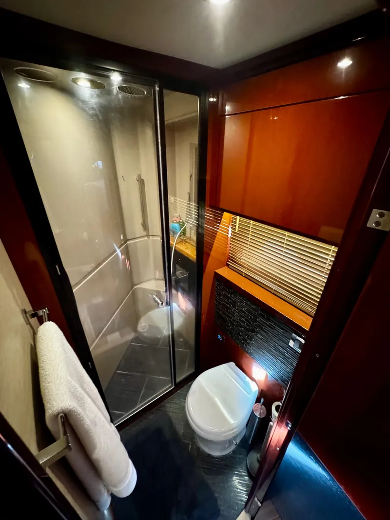 Slide: The Image of Luxurious bathroom in 2017 Sea Ray L590 yacht with modern fixtures and elegant wood finishes. - 28