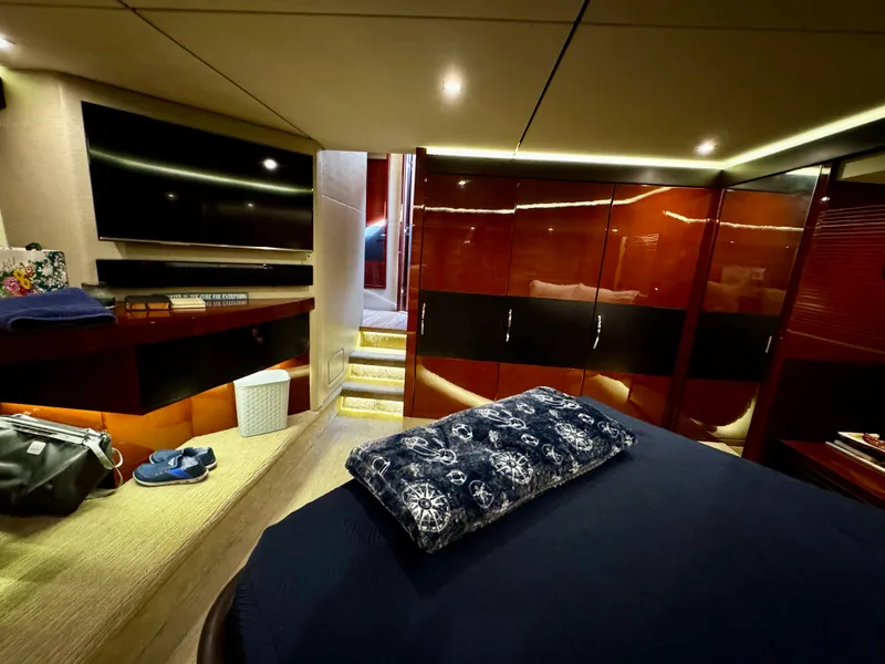 Slide: The Image of Luxurious 2017 Sea Ray L590 yacht interior with modern bedroom and sleek wooden cabinetry. - 32