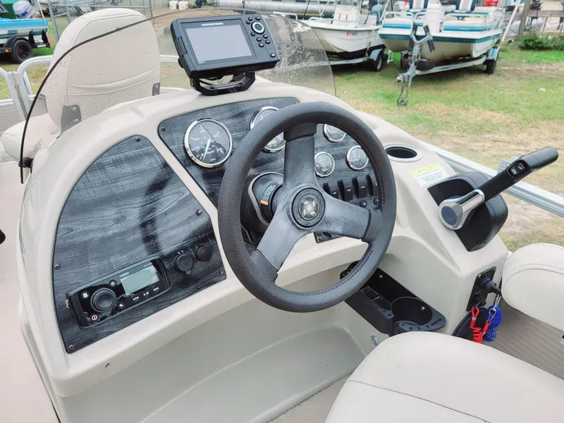 Slide: The Image of 2021 Godfrey SR 160 F boat dashboard with steering wheel and control panel. - 8