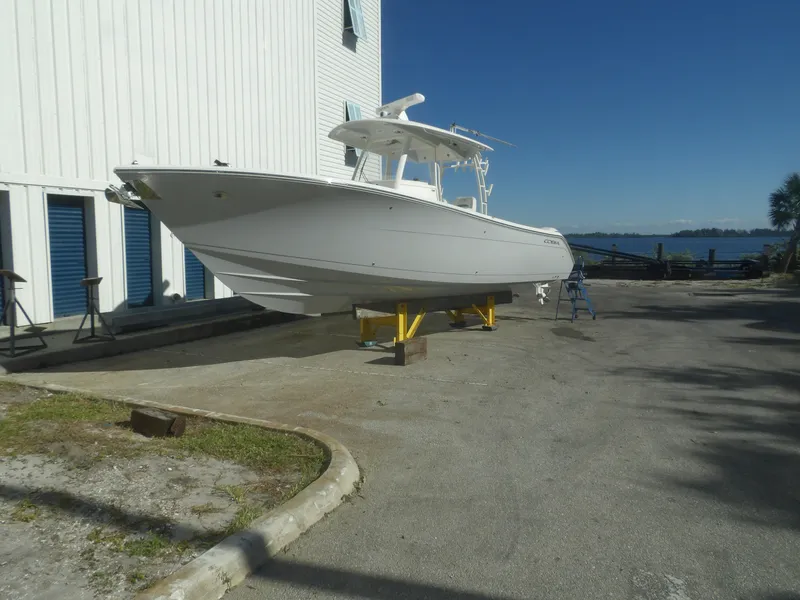 Slide: The Image of 2020 Cobia 320 Center Console boat on dry dock near waterfront. - 1