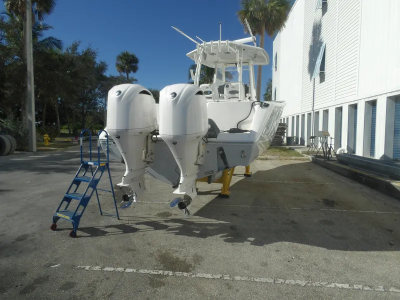 Slide: The Image of 2020 Cobia 320 Center Console boat with dual outboard engines on a trailer. - 10