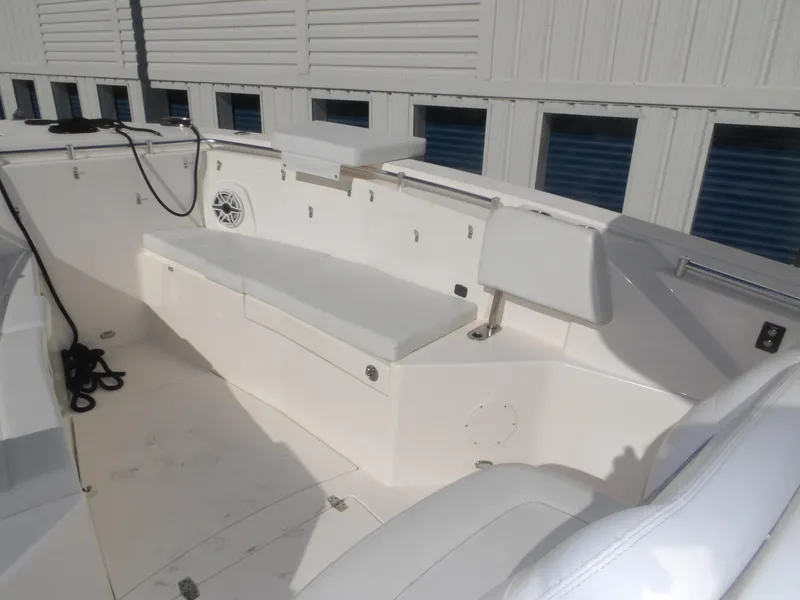 Slide: The Image of 2020 Cobia 320 Center Console boat interior with white seating and storage compartments. - 22