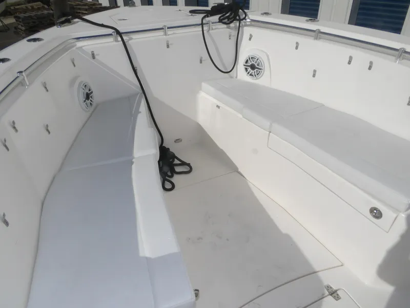 Slide: The Image of 2020 Cobia 320 Center Console boat interior with white seating and speakers. - 27