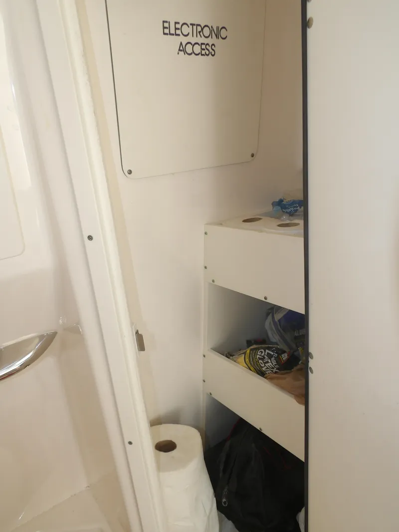 Slide: The Image of Interior storage area of 2020 Cobia 320 Center Console boat with electronic access panel. - 38