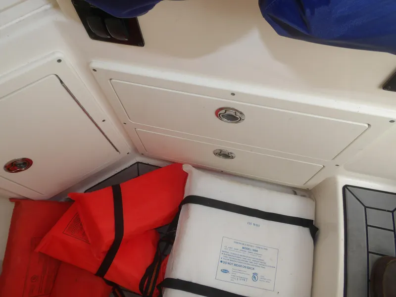 Slide: The Image of Storage compartment with life jackets on a 2020 Cobia 320 Center Console boat. - 39