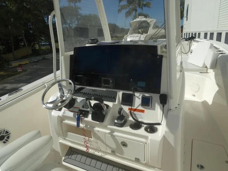 Slide: The Image of 2020 Cobia 320 Center Console boat dashboard with steering wheel and navigation controls. - 45