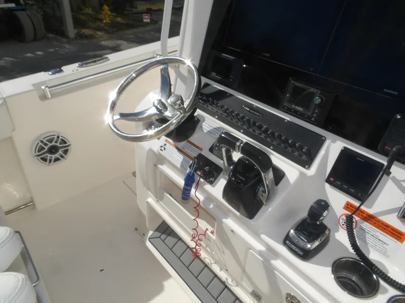 Slide: The Image of 2020 Cobia 320 Center Console boat dashboard with steering wheel and controls. - 47