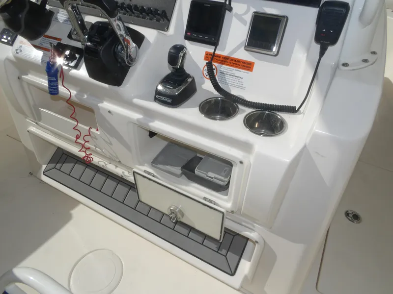 Slide: The Image of 2020 Cobia 320 Center Console boat dashboard with controls and storage compartments. - 49