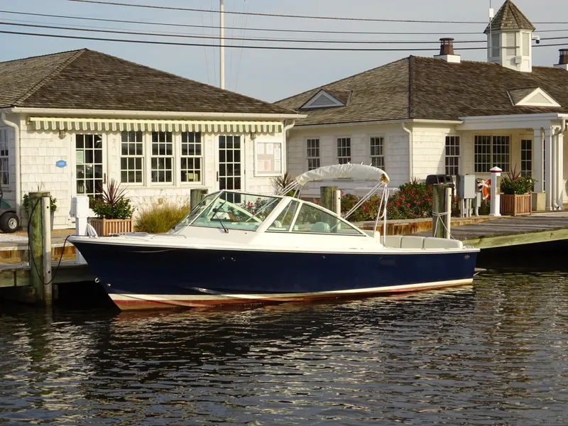 The Image of 2008 Hunt Yachts Harrier 25 docked near a waterfront building. - 0