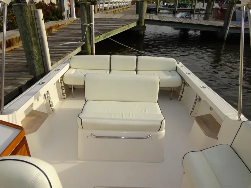 Slide: The Image of 2008 Hunt Yachts Harrier 25 boat interior with white seating at a dock. - 16
