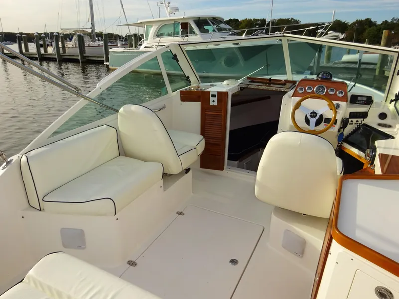 Slide: The Image of 2008 Hunt Yachts Harrier 25 interior with white seating and wooden dashboard. - 21