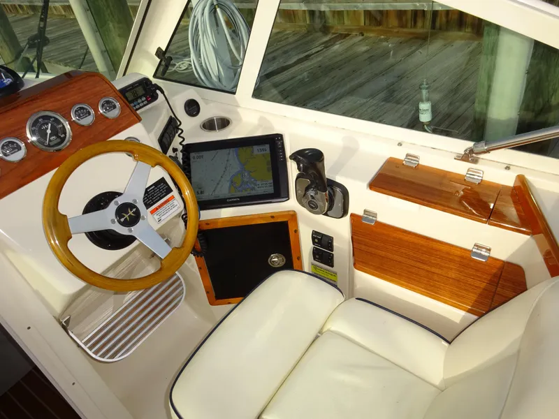 Slide: The Image of 2008 Hunt Yachts Harrier 25 cockpit with wooden steering wheel and navigation equipment. - 25