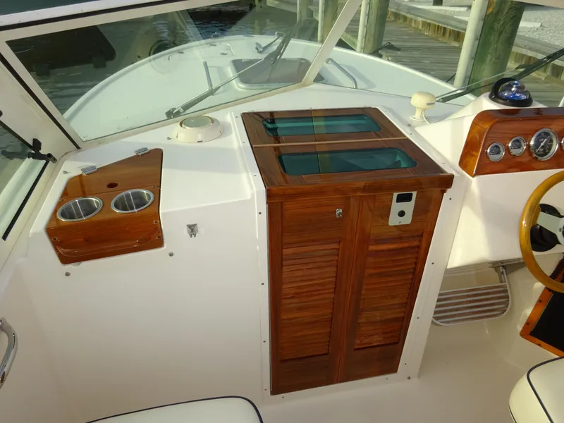 Slide: The Image of 2008 Hunt Yachts Harrier 25 cockpit with wooden cabinetry and dual cup holders. - 26