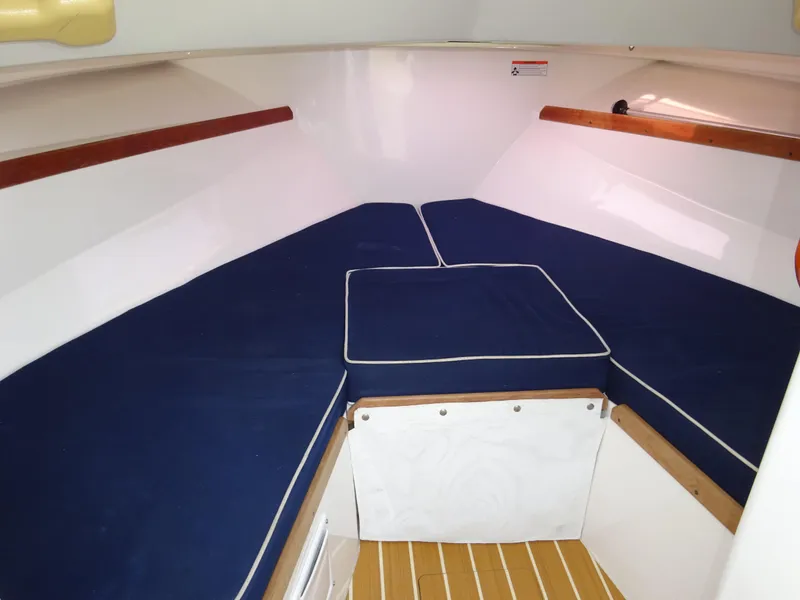 Slide: The Image of 2008 Hunt Yachts Harrier 25 cabin interior with blue cushions and wooden accents. - 27