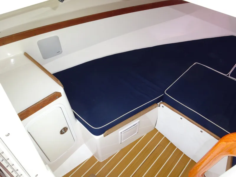 Slide: The Image of 2008 Hunt Yachts Harrier 25 cabin interior with blue cushions and wooden accents. - 28