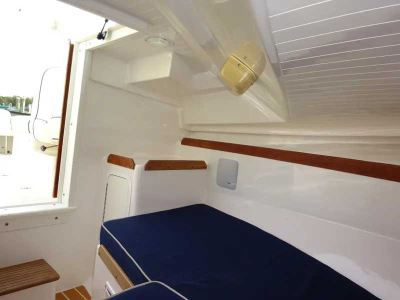 Slide: The Image of 2008 Hunt Yachts Harrier 25 cabin interior with blue seating and wooden accents. - 29