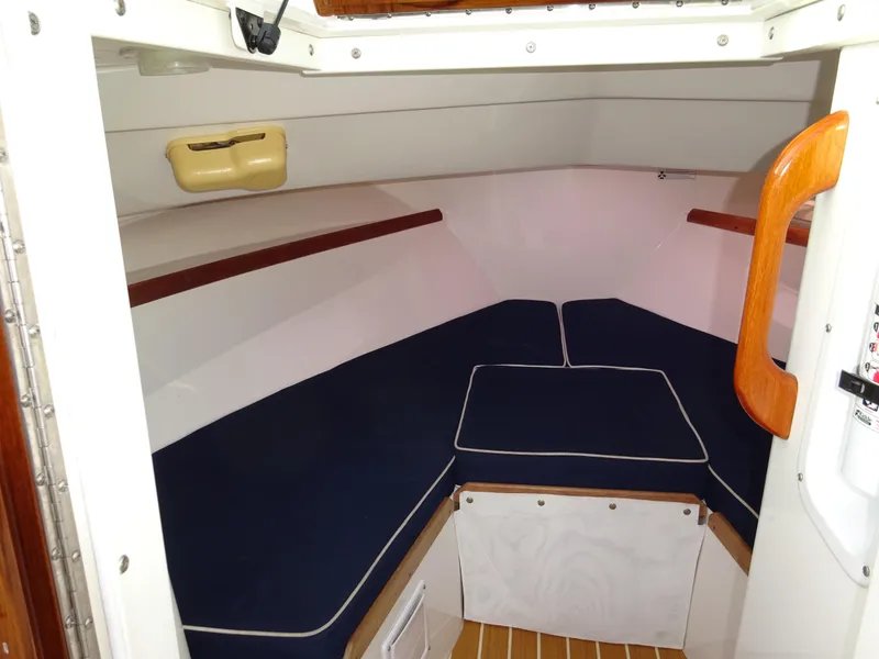 Slide: The Image of 2008 Hunt Yachts Harrier 25 cabin interior with blue cushions and wooden accents. - 3