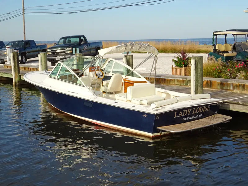 Slide: The Image of 2008 Hunt Yachts Harrier 25 docked, featuring sleek design and blue hull. - 5