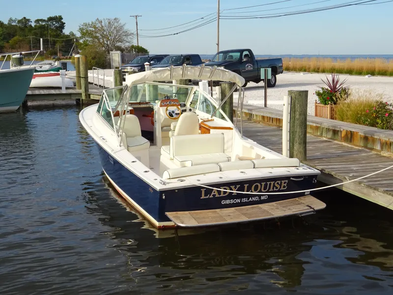 Slide: The Image of 2008 Hunt Yachts Harrier 25 docked, named "Lady Louise," at a marina with scenic background. - 6