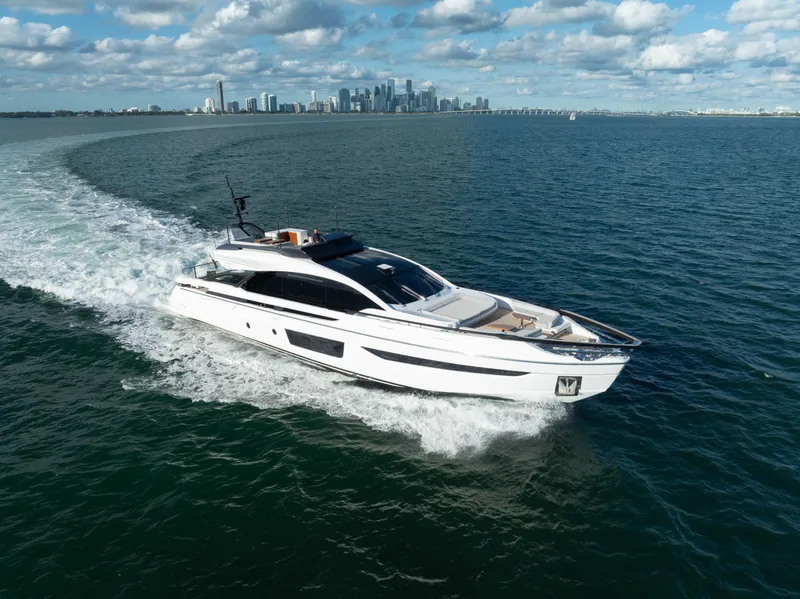 Slide: The Image of Azimut S10 2021 yacht cruising on open water with city skyline in background. - 0