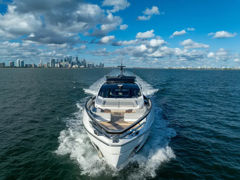 Slide: The Image of Azimut S10 yacht cruising on open water with city skyline in background. - 10