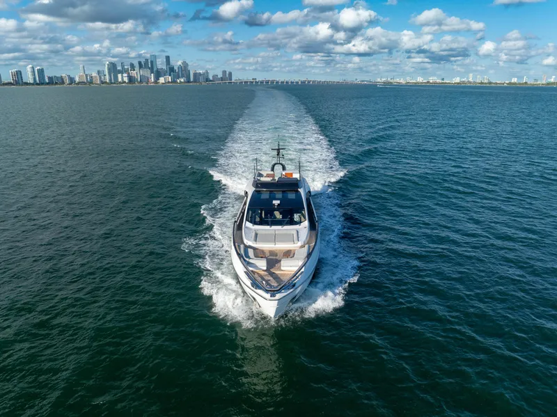 Slide: The Image of Azimut S10 yacht cruising on open water with city skyline in background. - 12