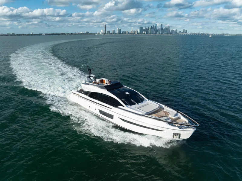 Slide: The Image of Azimut S10 2021 luxury yacht cruising on open water with city skyline backdrop. - 13