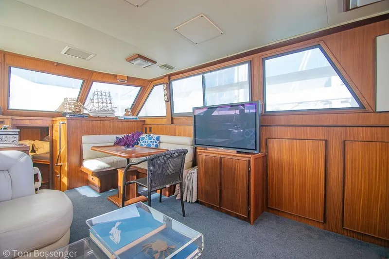 Slide: The Image of Interior of 1986 Hatteras 43 Motor Yacht with wood paneling, seating, and TV. - 11