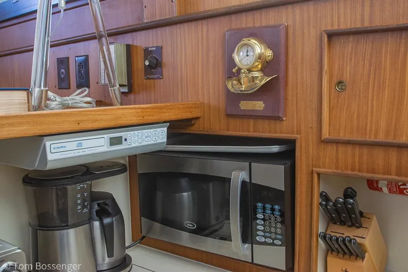 Slide: The Image of 1986 Hatteras 43 Motor Yacht kitchen with microwave, coffee maker, and wall-mounted clock. - 22