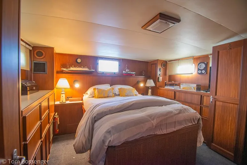 Slide: The Image of Cozy bedroom in 1986 Hatteras 43 Motor Yacht with wood paneling and soft lighting. - 24