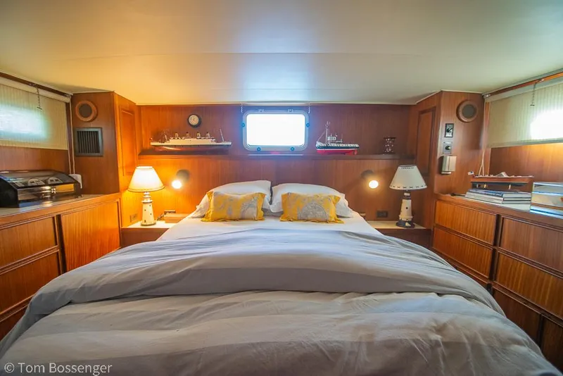 Slide: The Image of Cozy bedroom interior of 1986 Hatteras 43 Motor Yacht with wooden furnishings and soft lighting. - 25