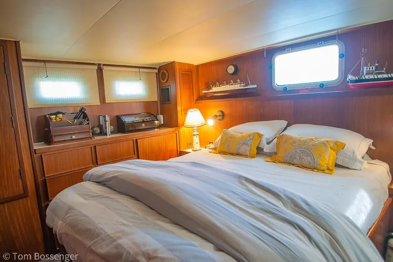 Slide: The Image of Cozy bedroom in 1986 Hatteras 43 Motor Yacht with wooden decor and nautical accents. - 26