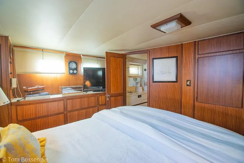 Slide: The Image of Interior of 1986 Hatteras 43 Motor Yacht bedroom with wood paneling and cozy decor. - 27