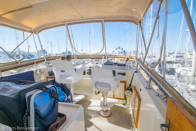 Slide: The Image of Interior view of 1986 Hatteras 43 Motor Yacht helm with white chairs and navigation equipment. - 40