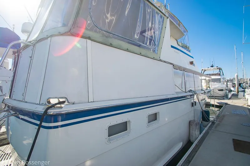 Slide: The Image of 1986 Hatteras 43 Motor Yacht docked, showcasing sleek design and classic white exterior. - 49