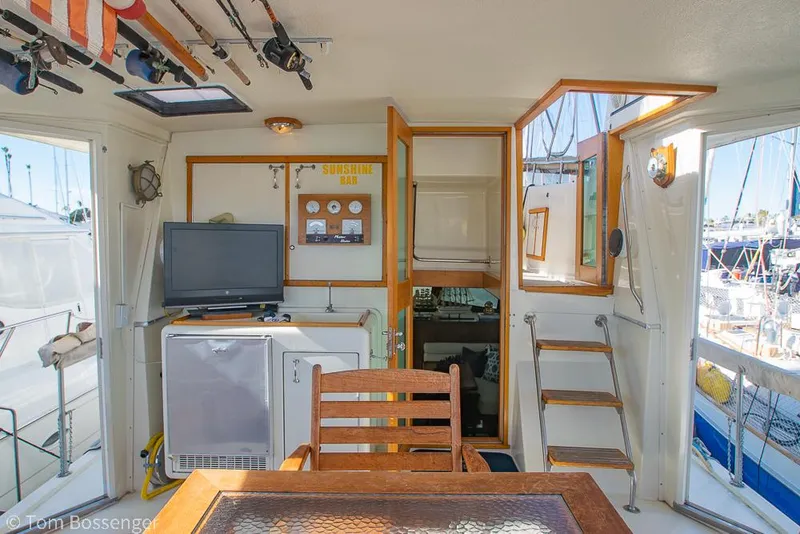 Slide: The Image of 1986 Hatteras 43 Motor Yacht interior with TV, fridge, and wooden furniture. - 7