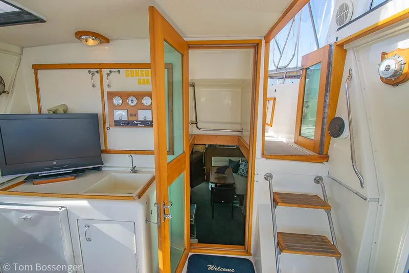 Slide: The Image of Interior of 1986 Hatteras 43 Motor Yacht with TV, wooden accents, and nautical decor. - 8