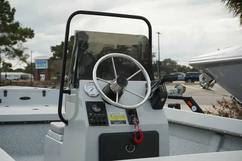 Slide: The Image of Mi Tide V1602 boat console with steering wheel, 2025 model, parked outdoors. - 6