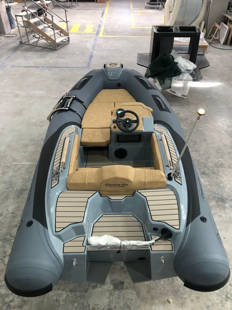 Slide: The Image of 2025 Ranieri CAYMAN ONE LUXURY TENDER, sleek design, gray and tan interior, in a workshop setting. - 10