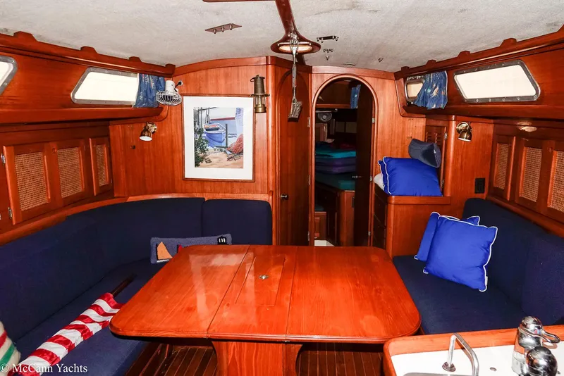 Slide: The Image of 1988 Bristol 41.1 Aft Cockpit interior with wooden dining area and blue cushions. - 19