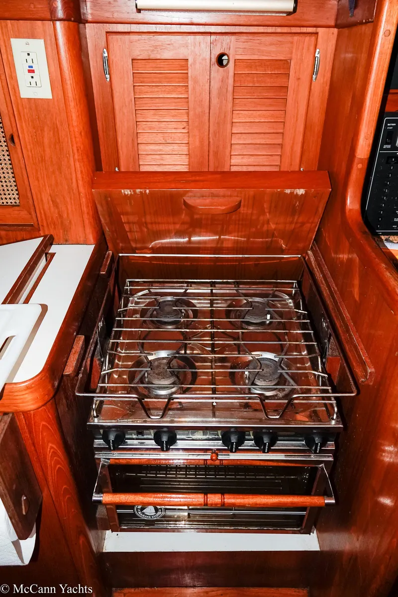 Slide: The Image of 1988 Bristol 41.1 Aft Cockpit yacht kitchen with wooden cabinetry and gas stove. - 23
