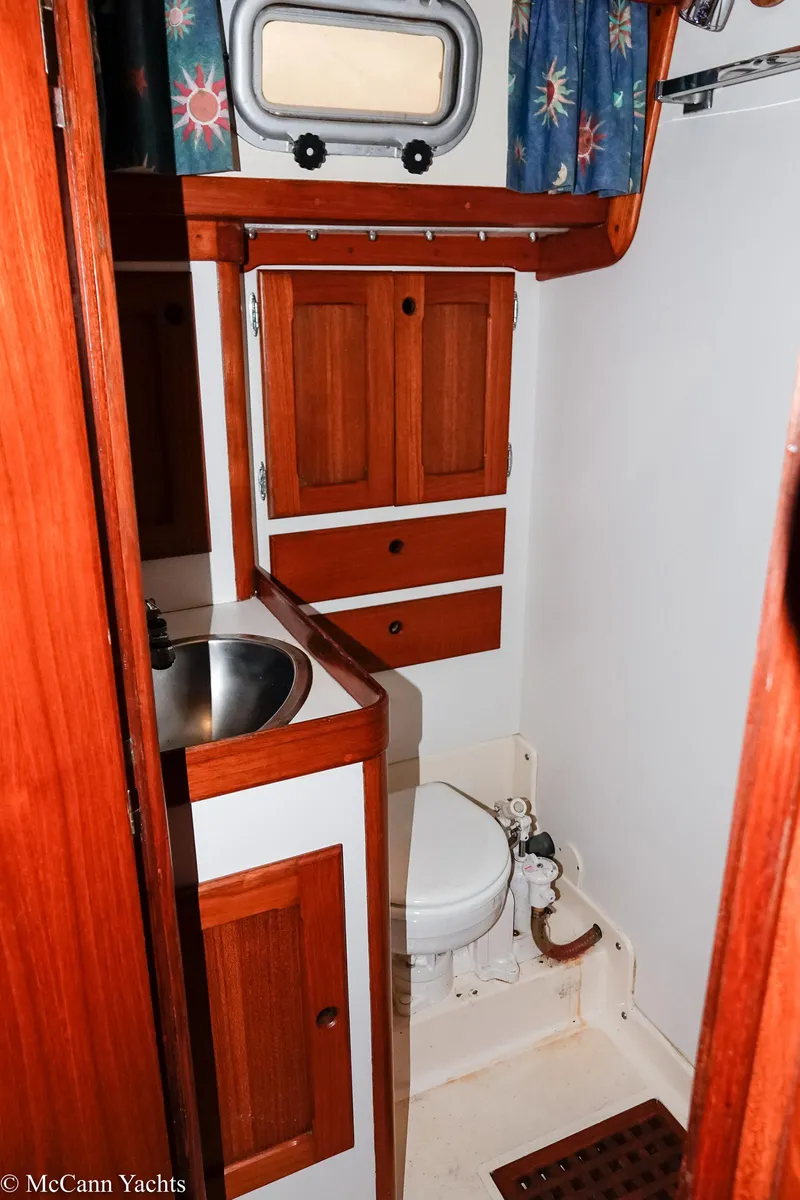 Slide: The Image of 1988 Bristol 41.1 Aft Cockpit yacht bathroom with wooden cabinets and stainless steel sink. - 42