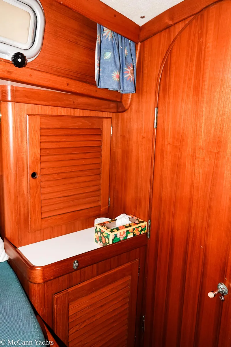 Slide: The Image of 1988 Bristol 41.1 Aft Cockpit interior with wooden cabinetry and floral curtain. - 43