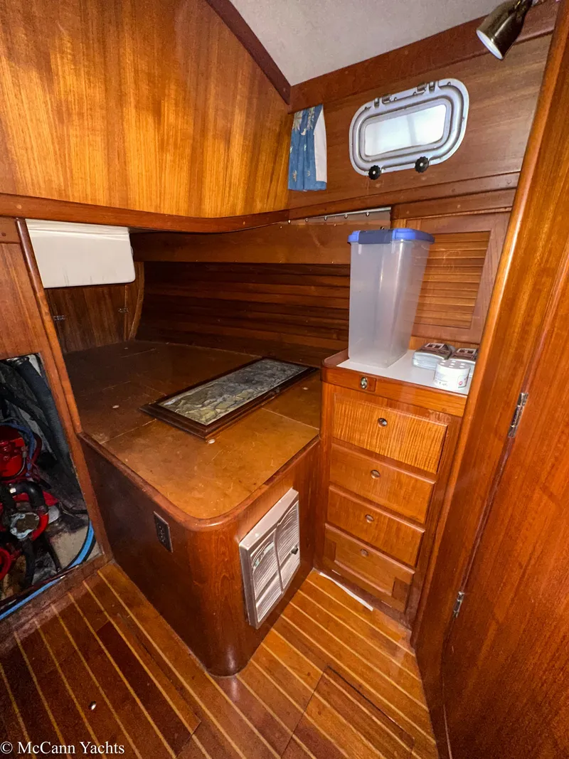 Slide: The Image of 1988 Bristol 41.1 Aft Cockpit interior with wooden cabinetry and small porthole window. - 47