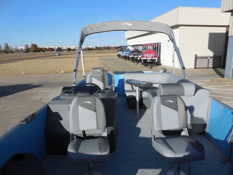 Slide: The Image of 2025 Bennington 188 SF pontoon boat with gray seating and canopy, parked outdoors. - 5