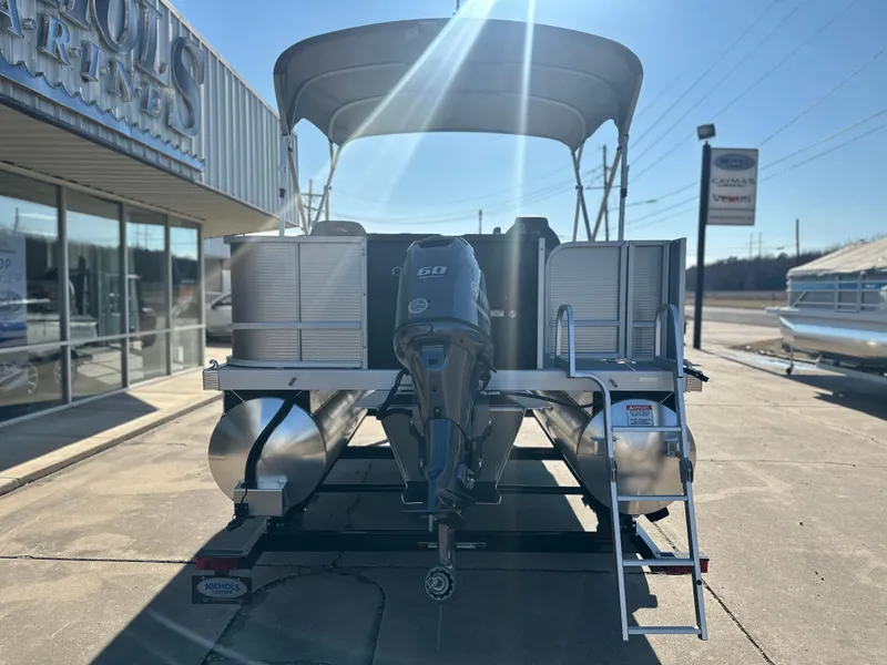 Slide: The Image of 2025 Bennington 188 SF pontoon boat with canopy and motor, displayed at a dealership. - 3