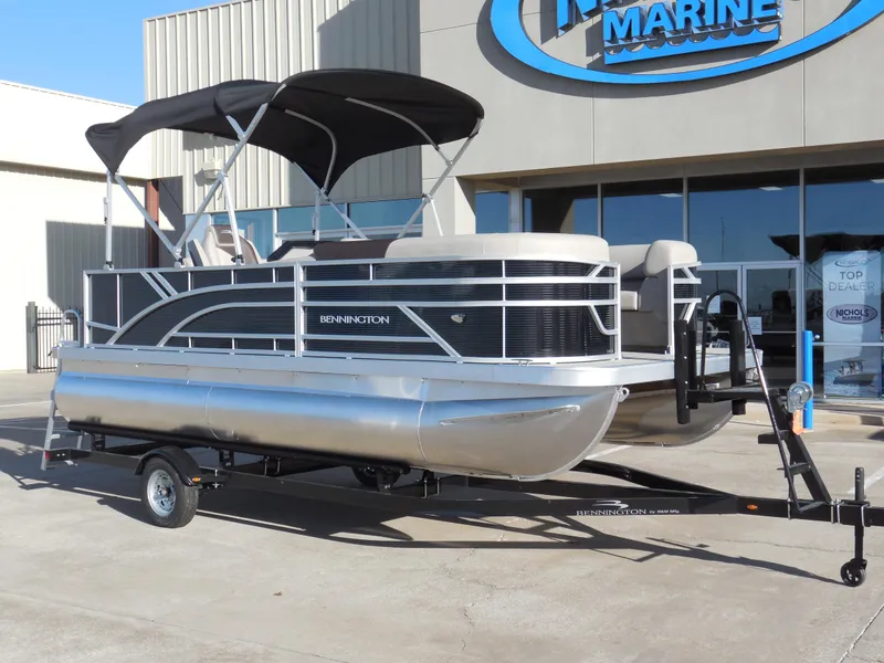 Slide: The Image of 2025 Bennington 188 SL pontoon boat on trailer outside marine dealership. - 2