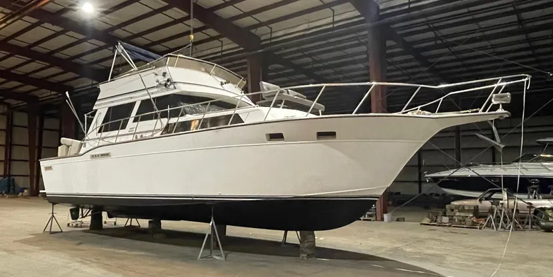 Slide: The Image of 1989 Marinette 41 Marquis Convertible boat in indoor storage facility. - 0