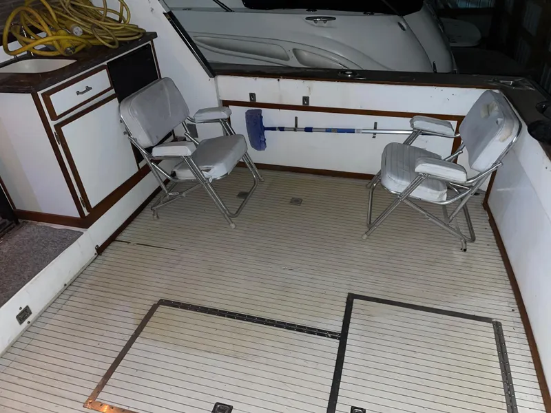 Slide: The Image of 1989 Marinette 41 Marquis Convertible boat deck with chairs and storage compartments. - 23