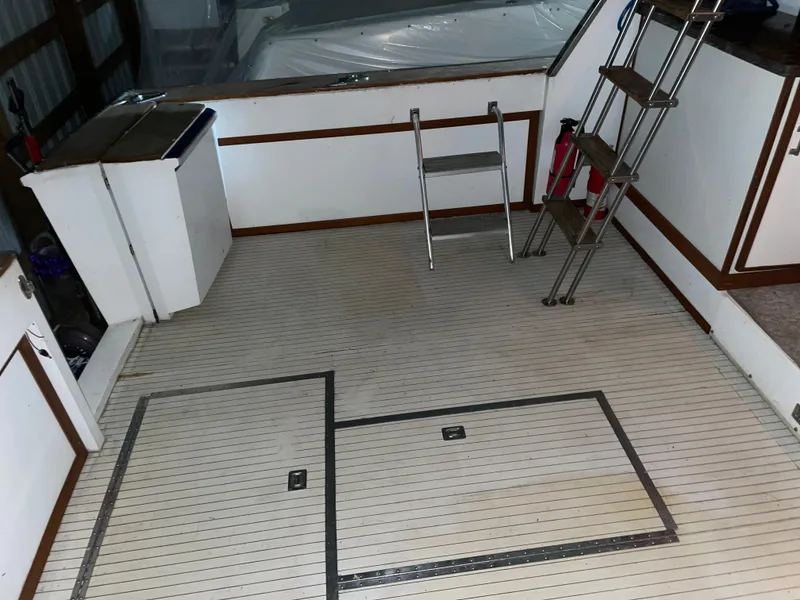 Slide: The Image of 1989 Marinette 41 Marquis Convertible boat deck with ladder and storage compartments. - 24